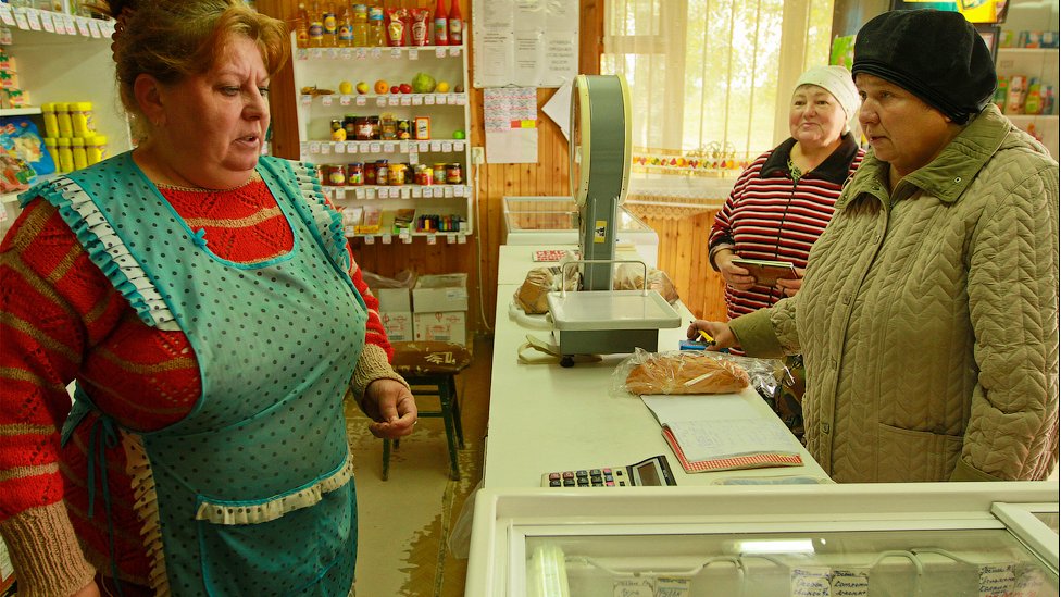 A photograph shows a shopkeeper and customers across a shop counter, with the caption “Russian shopkeepers should be more friendly”.