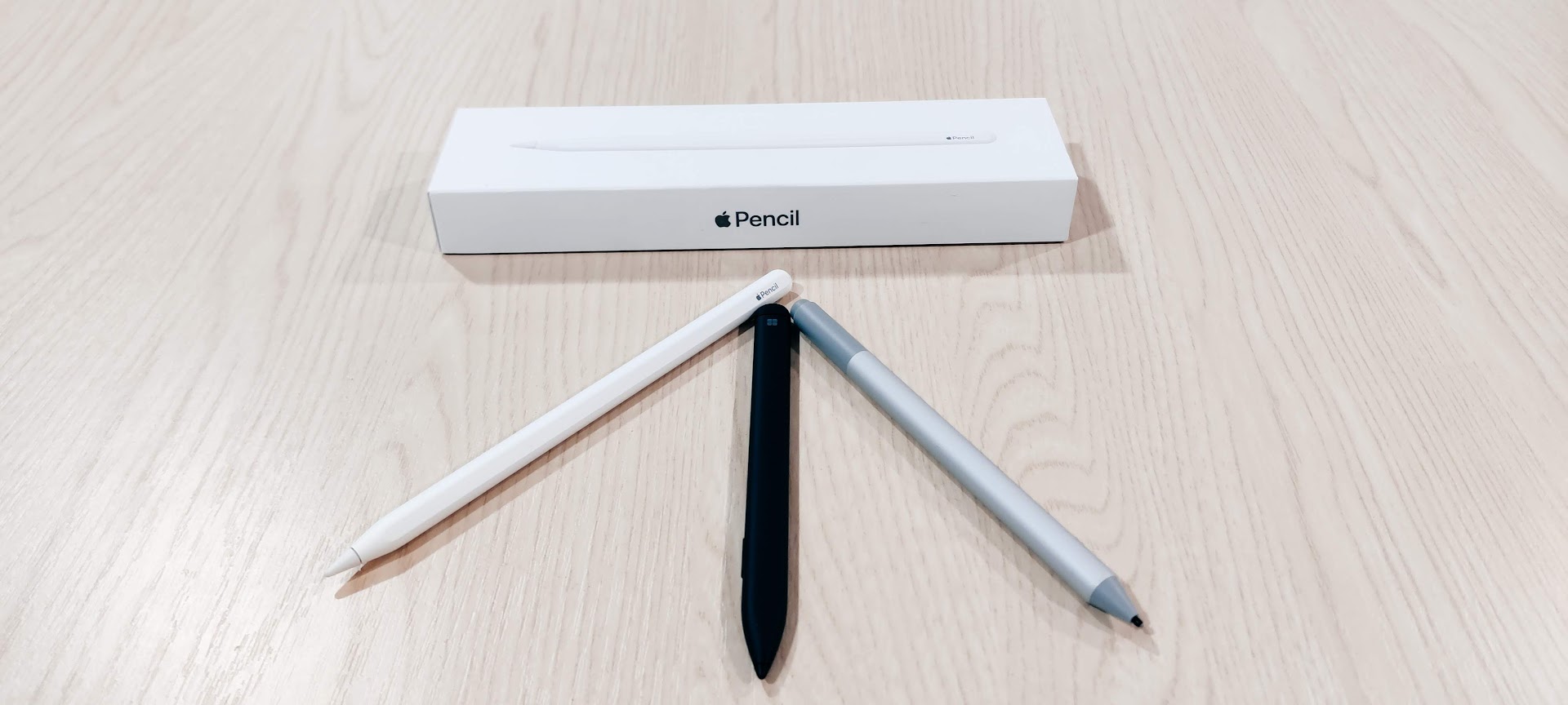 Photograph of an Apple Pencil box with an Apple Pencil and two other active styluses.