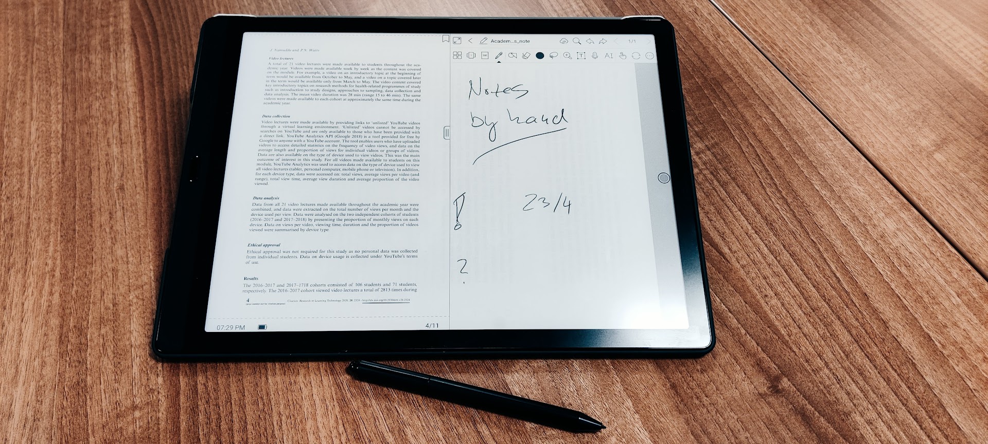 Photograph of an Onyx Boox tablet showing a page with handwritten notes, with its pen on the table.