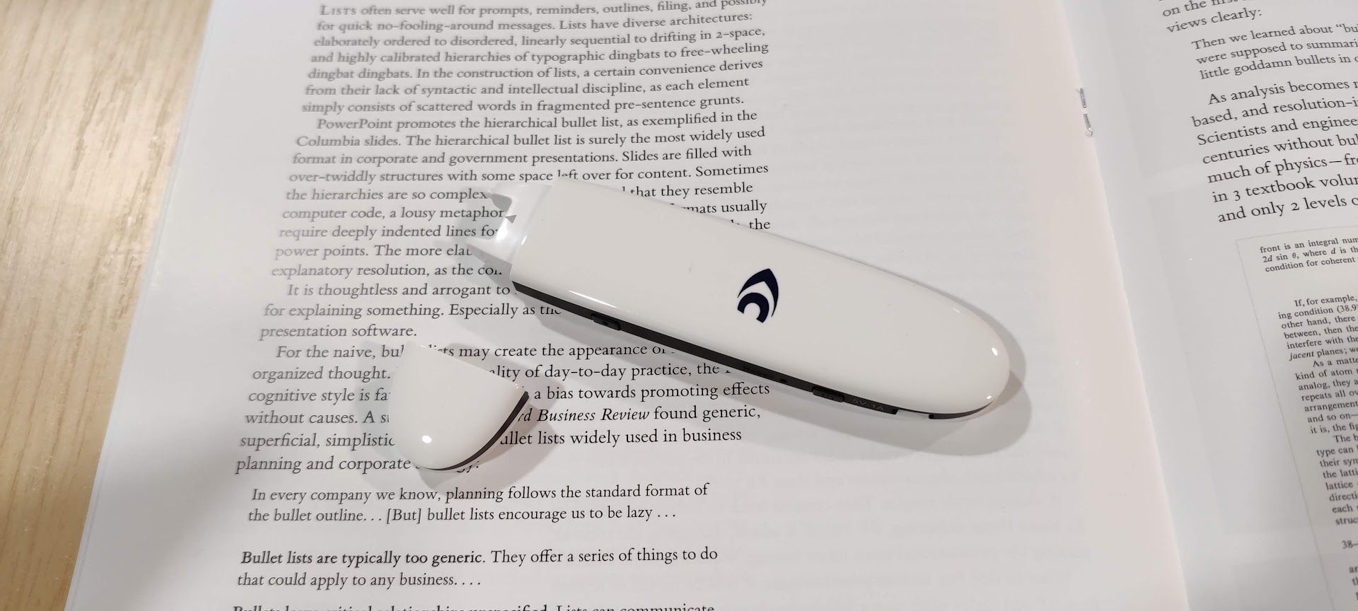 Photograph of a white pen scanner resting on a printed page.
