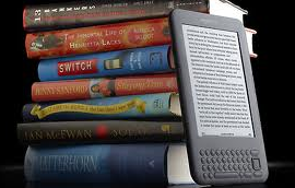 An e-reader displaying text beside a stack of printed books.
