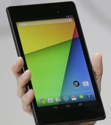 A hand holds a tablet whose screen shows a colourful home screen.