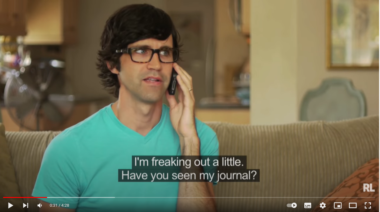 Still frame from a comedy video of a man in a teal T-shirt, with a poorly recognised caption beneath him.